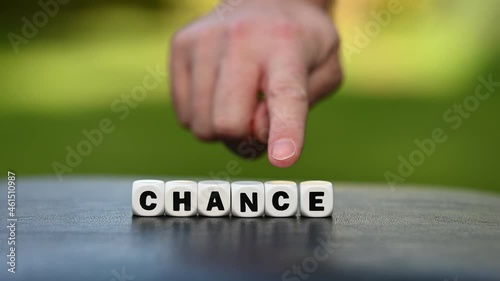 Hand is turning a dice and changes the word chance to change. photo