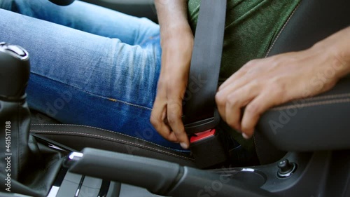 Close Up Of Male Driver Fastening Seatbelt Before Setting Off On Car Journey