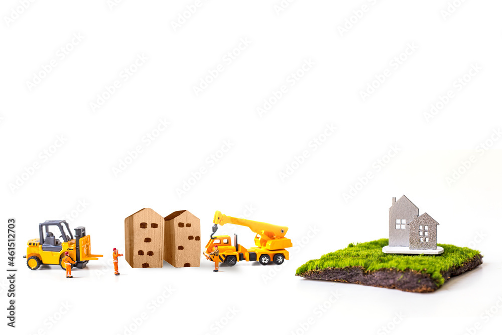 miniature house with miniature worker and wood blog isolated on white background.
