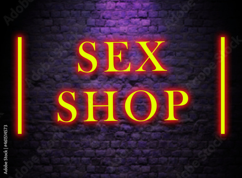 Sex Shop neon Sign in dark Wall Brick background. Yellow Glowing text in pink texture wall. 