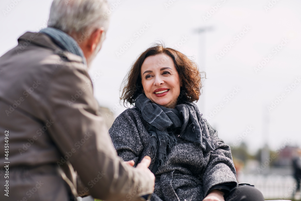 Couple sitting on bench and talking together Couple sitting on bench and talking together