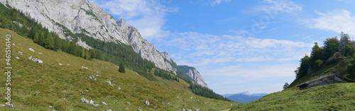 Panoramaaufnahme - Wanderweg zur Halsalm mit hohem Gerstfeld und Hütte photo