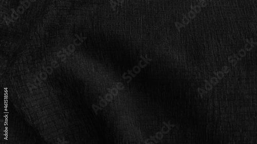 close up luxury elegance wavy and fold silk fabric texture in dark black color tone. abstract background of fabric with blank space for design.