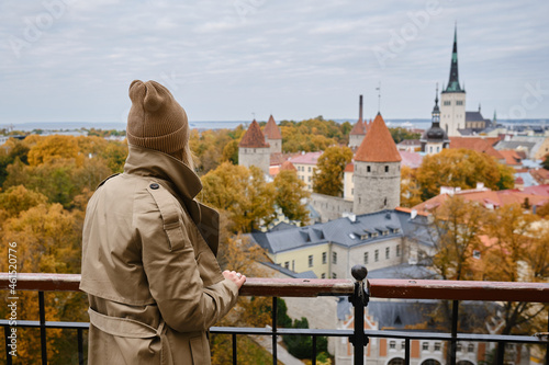 Blonde woman enjoy panorama of the city of Tallinn. Amazing scenic view of the old town. Girl explore Estonia, Europe. City and sea. City autumn landscape, old historical architecture