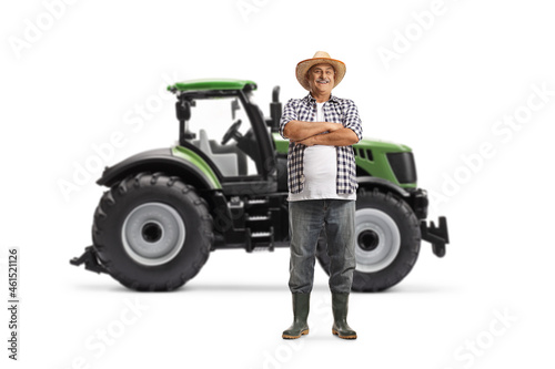 Full length portrait of a farmer standing in front of a green tractor