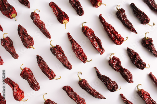 Pattern backrground with dried red peppers on white background. Jalapeno paprika. photo