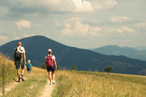 Family walks along a mountain road in the Carpathians.