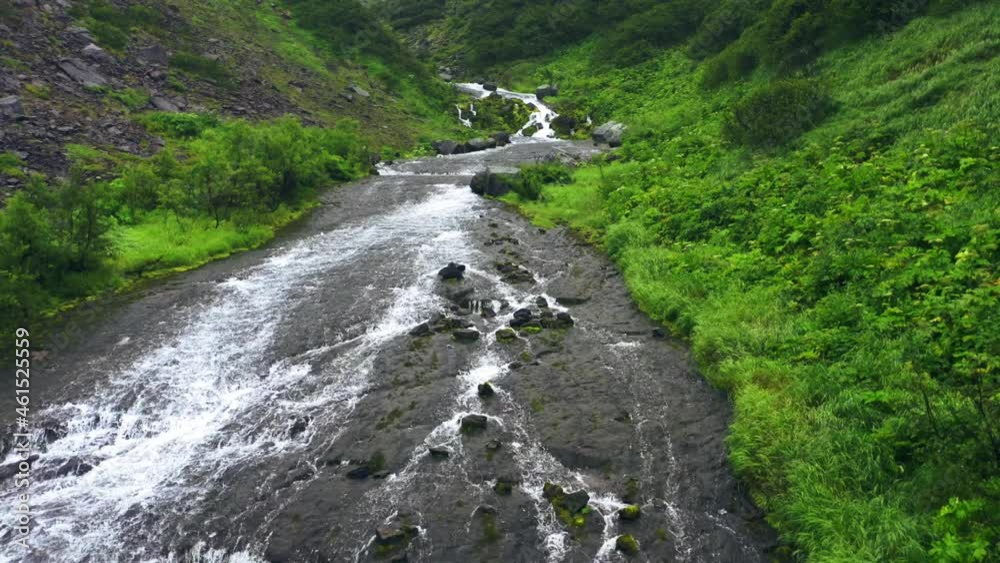 Kamchatka,Russia-Aug 27,2020:Slow motion flyout from the waterfall and river with forest around.4k,footage Kamchatka,Russia-Aug 27,2020:Slow motion flyout from the waterfall and river with forest around.4k,footage