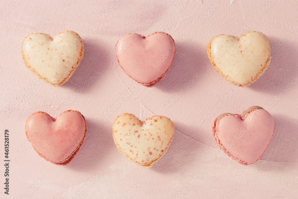 Obraz premium Delicious French macarons in heart shape on pink background