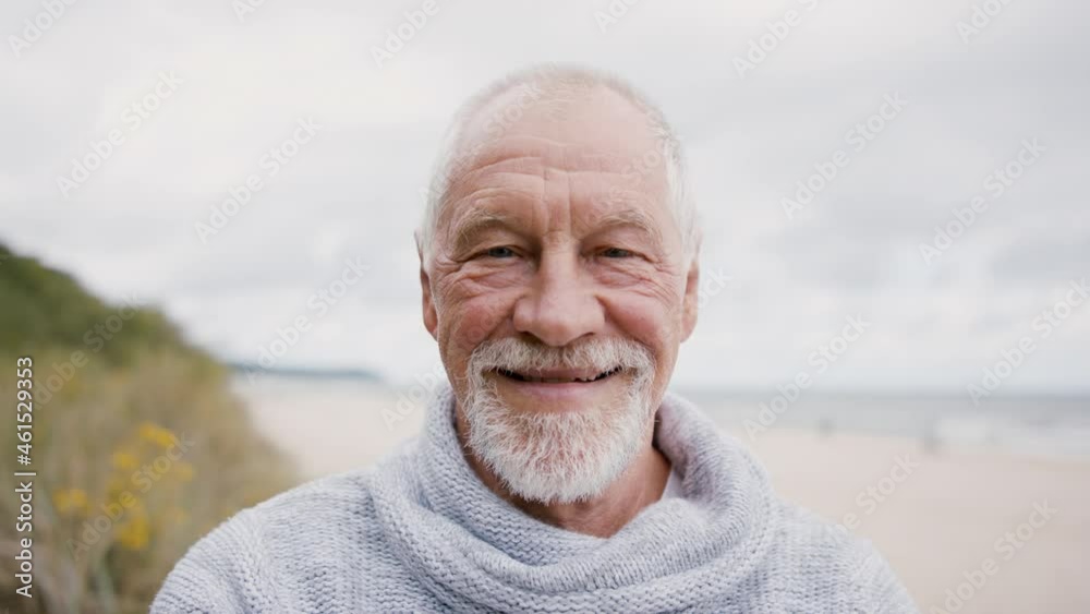 Senior man tourist loooking at camera outdoors on beach. Senior man tourist loooking at camera outdoors on beach.