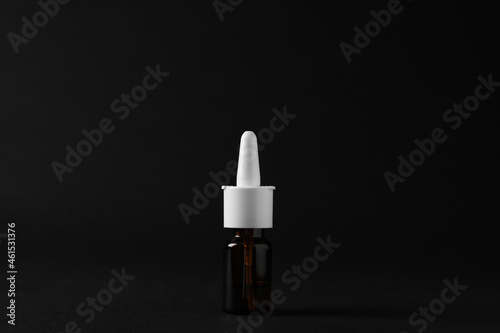 Bottle of nasal spray on black background