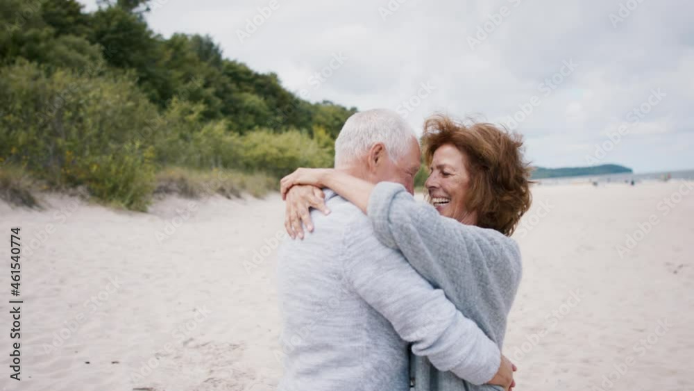 Happy senior couple in love on walk outdoors on beach at morning, hugging. Happy senior couple in love on walk outdoors on beach at morning, hugging.