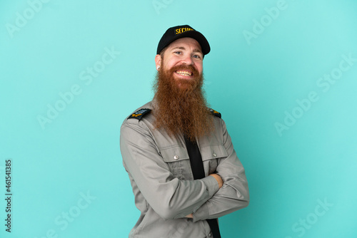 Redhead security man isolated on white background with arms crossed and looking forward