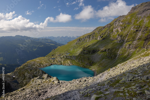 A wonderful view to the horizon at a beautiful sunset in the alps of Switzerland by an alpine lake called Schottensee. These colors by the sunset are just amazing. Epic clear blue water. © Philip