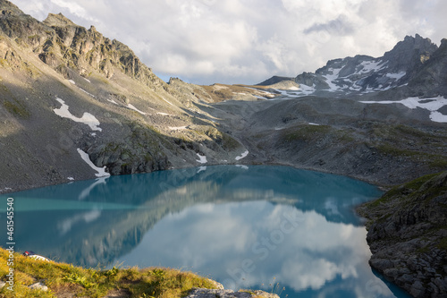 Wonderful scenery at an alpine lake called Wildsee in the canton of Saint Gallen. Epic sunset in the alps of Switzerland. Beautiful view with the tent in front and a perfect camping day.