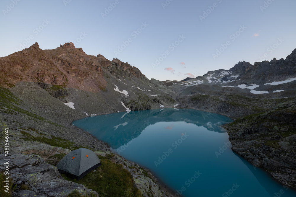 Obraz premium A wonderful view to the horizon at a beautiful sunset in the alps of Switzerland by an alpine lake called Schottensee. These colors by the sunset are just amazing. Epic clear blue water.