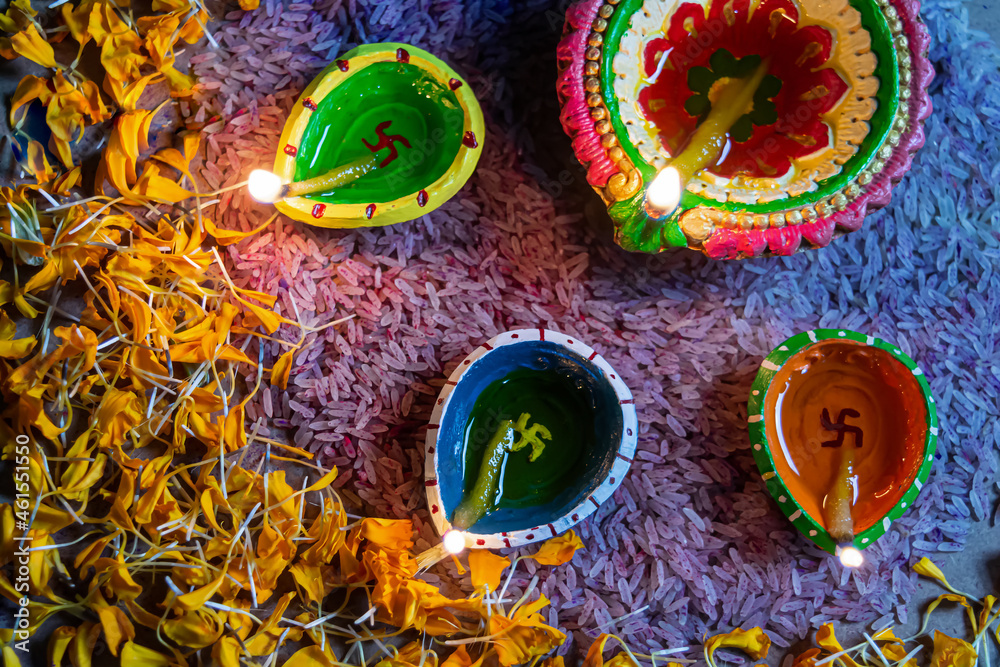 Happy Diwali - Colorful clay diya or oil lamps lit during Deepavali.
