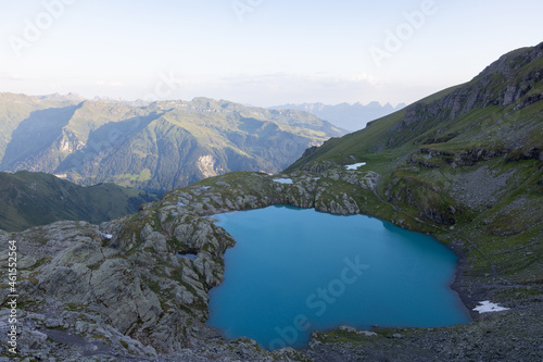 Wonderful view over a beautiful alpine lake in Switzerland called Schottensee. Epic sunrise over a perfect blue lake.