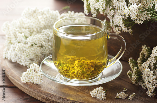 Yarrow herbal healing tea or decoction with fresh milfoil flowers close on rustic table on wooden background, closeup, copy space, natural medicine and naturopathy concept photo