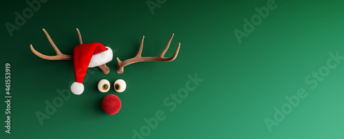 Tableau sur toile Reindeer with red nose and Santa hat on green Christmas background 3D Rendering,