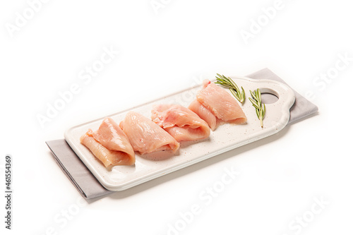 filetes de pollo pavo fresco crudo en plato blanco sobre servilleta de tela gris decorado con especias. aislada fondo blanco