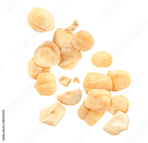 Pieces of tasty hazelnuts falling on white background