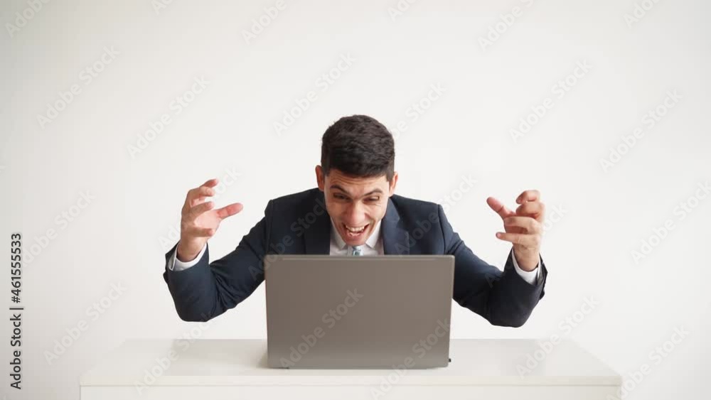 Happy office worker in formal clothes jacket and tie works laptop and funny rejoices successful deal on white background. Emotions joy and happiness employee. Great job and career growth. Slow motion Happy office worker in formal clothes jacket and tie works laptop and funny rejoices successful deal on white background. Emotions joy and happiness employee. Great job and career growth. Slow motion