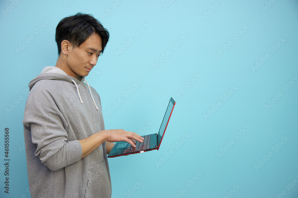 ノートパソコンと灰色のパーカーの日本人男性 ノートパソコンと灰色のパーカーの日本人男性