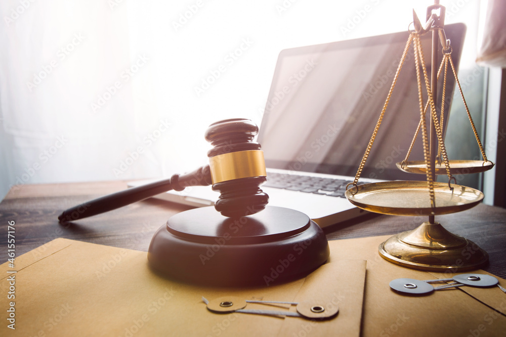 law legal technology concept. judge gavel on computer with scales of justice on desk of lawyer. law legal technology concept. judge gavel on computer with scales of justice on desk of lawyer.