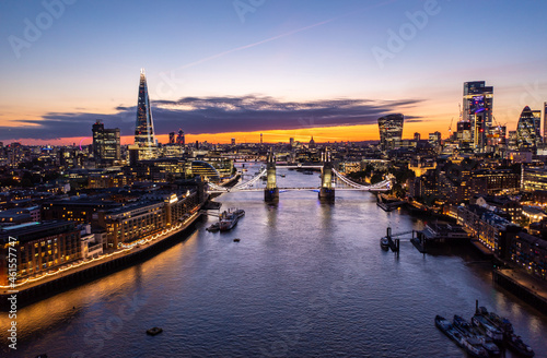 Tower Bridge with illuminated lights over Thames River, Aerial View