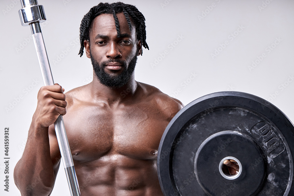 Training to be the best.Perfect biceps. fitness and sport equipment. african shirtless sportsman with strong hands holding weights, having athletic body. Muscular man exercising with barbell.