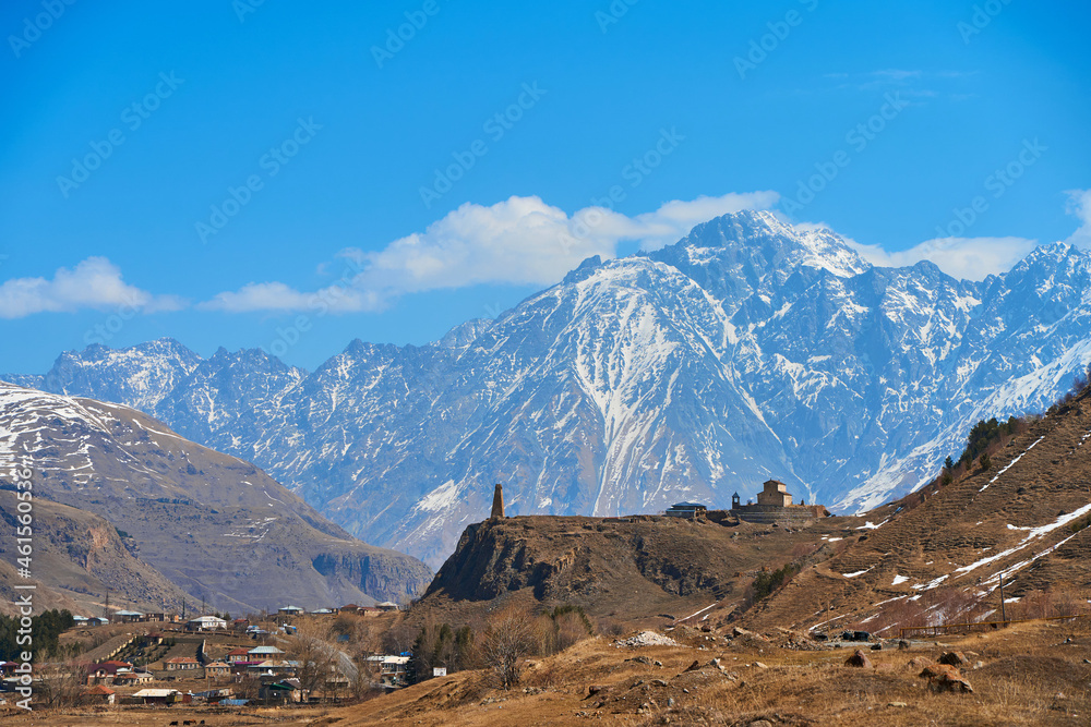 In a mountain valley, a breathtaking landscape of giant covered mountains in the background