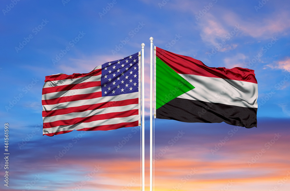 Waving American flag and flag of Sudan. Closeup view,
