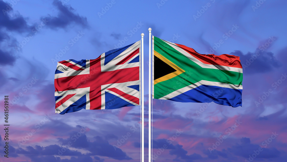 United Kingdom and South Africa two flags on flagpoles and blue cloudy sky