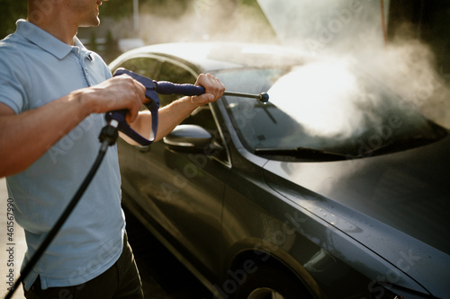 Man holds high pressure water gun, hand car wash