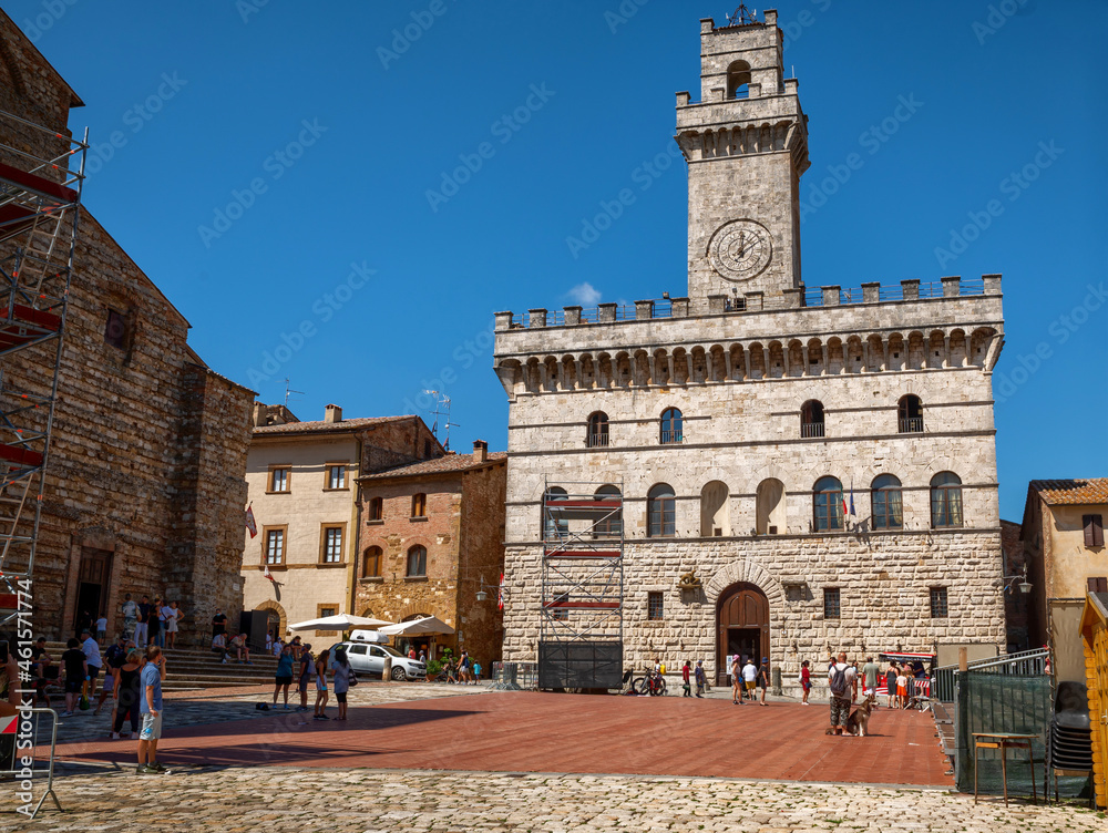 Montepulciano, Tuscany, Italy. August 2021. Piazza grande is the main square of the historic center, where the town hall overlooks with the tower with the clock in evidence. People in the square.