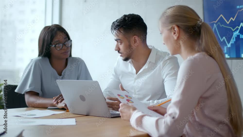 Business and teamwork. Happy diverse coworkers working together discussing project strategy on laptop at office Business and teamwork. Happy diverse coworkers working together discussing project strategy on laptop at office