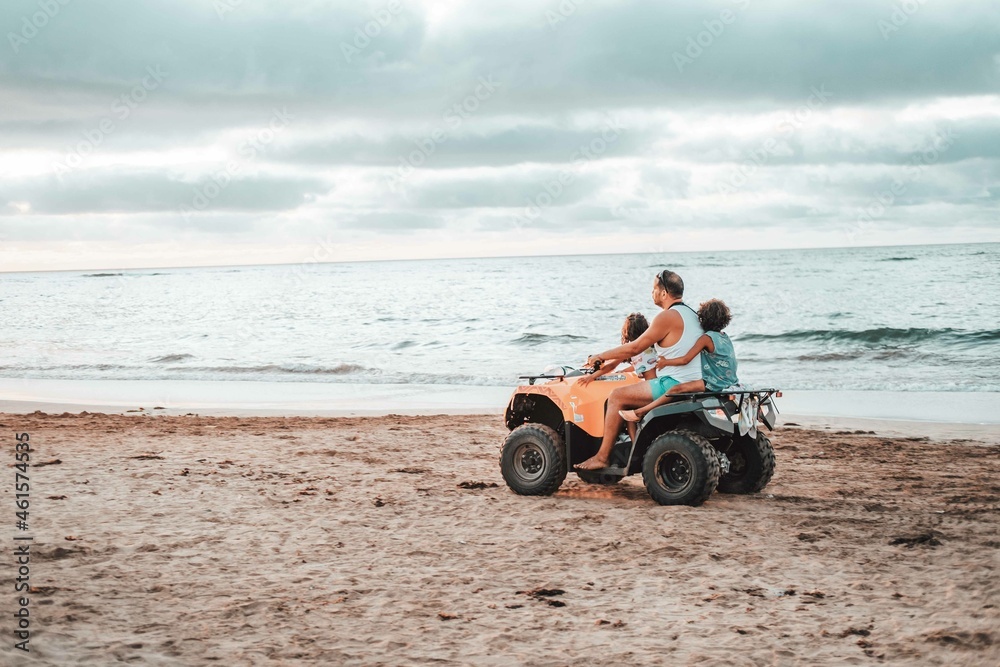Casablanca, Morocco 04-10-2021: a father with two children driving a quad in a beach in Morocco Casablanca, Morocco 04-10-2021: a father with two children driving a quad in a beach in Morocco