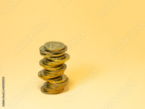 A turret made of coins. Money on yellow background