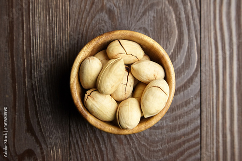Pecan nuts in bowl on wooden table top view