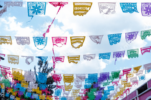 Colorful Mexican paper banners under slightly cloudy sky