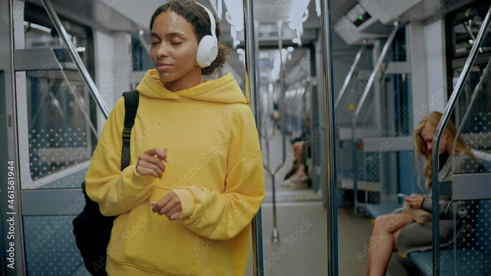 Young girl enjoying music in headphones in modern train, smiling and singing along the music. High quality 4k footage Young girl enjoying music in headphones in modern train, smiling and singing along the music. High quality 4k footage