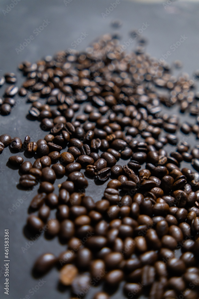 Pile of roasted coffee beans on dark gray surface Pile of roasted coffee beans on dark gray surface