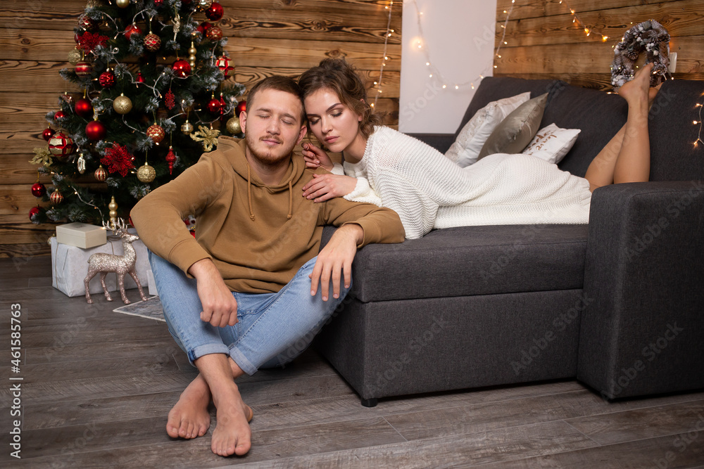 Obraz premium Couple in love near nicely decorated Christmas tree, enjoying the Christmas