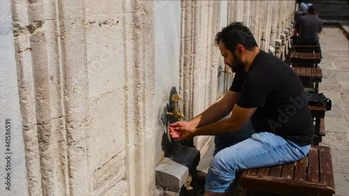 ablution, man performs ablution in a historical mosque, wudu man