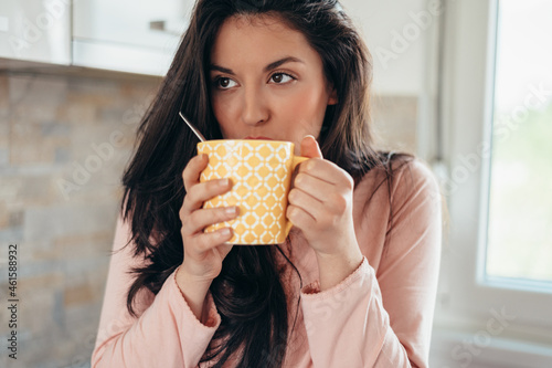Woman drinking cup of coffee and enjoying morning at home