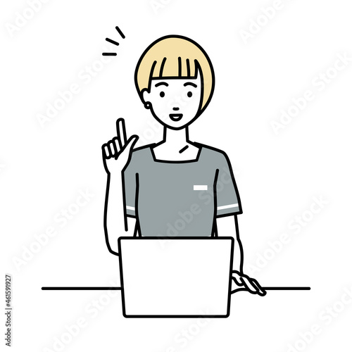 デスクで座ってPCを開いて何かひらめいたエステ店員の女性