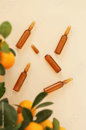 Vitamin C. Mesotherapy serum with vitamin C.Glass ampoules and tangerine fruit on beige background.ampoules and Serum with Vitamin C. Organic natural cosmetics.Health and Beauty 