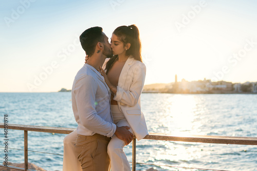 Photography Ethnic couple in love kissing on sea embankment
