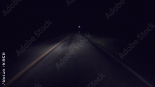 POV FPV driving in the rain at night on a dark country road passing a car